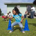 Chloe Gray, 4, a student at Train up a Child Christian Learning Center in Clinton, takes a leap during physical development activities as part of the Nurturing Homes Initiative. (Photo by MSU School of Human Sciences/Alicia Barnes)
