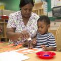 Penny Lee, a teacher at Global Connection Learning Center in Jackson, helps 2-year-old Jacob Sargent with an art project. Early care and education providers like Lee will be honored on Provider Appreciation Day May 10. (Photo by MSU School of Human Sciences/Alicia Barnes)