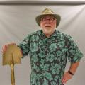 A smiling man wearing a cowboy hat and Hawaiian shirt.