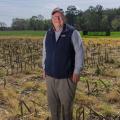 A man standing in a harvested field.