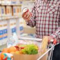 A person reads a Nutrition Facts label on a can of food in the grocery store.