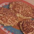 Three corn pancakes on a terra cotta plate. 