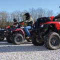 Several men on ATVs lined up.