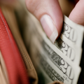 a closeup of a person taking $20 dollar bills out of a wallet