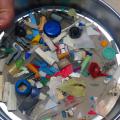 Looking down on a round pan with various small pieces of plastic.