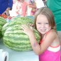 Emily Grace Barnette is ready to take this watermelon home from the Starkville Community Market on June 21, 2016. (Photo by MSU Extension Service/Linda Breazeale)