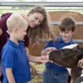 Carley Wigley, a senior at Mississippi State University from Petal, Mississippi, introduces Luke Iglay and Sam Eifling to a calf during “Afternoon on the Farm,” on April 29, 2016. The outreach program is part of the MSU Department of Animal and Dairy Science capstone course and teaches visiting students the fundamentals of livestock agriculture. (Photo by MSU Extension Service/Kat Lawrence)
