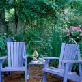 The mirror hanging on the tree over the left Adirondack chair blends comfortably into this lovely home-like setting.