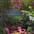 The Adirondack chair is a style of furniture that has stood the test of time and reached heirloom status. These hot pink chairs and matching table are flanked by tall crape myrtles of a similar color.