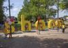 Children stand and sit around life-size, bright-yellow letters that spell out “share.”