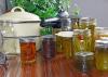 Canning equipment and canned foods sit on a counter.