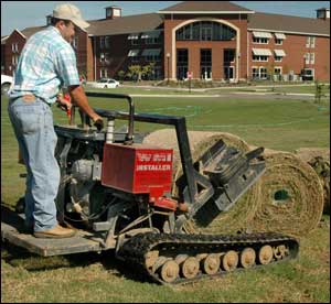 Steve Hughes lays down sod near one of Mississippi State University’s new residence halls.