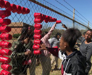 Kick Butts Day is spelled out with red cups in fence holes for awareness.